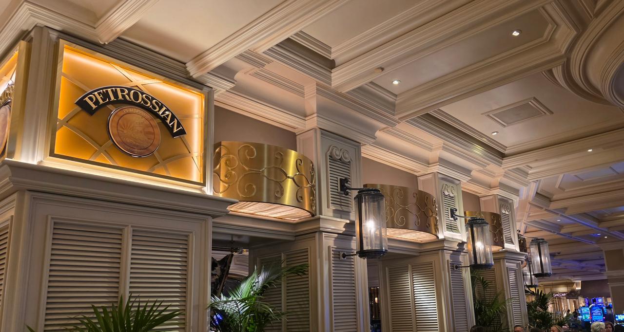 A formal lounge area with plush sofas, low lighting, and a pianist playing at a grand piano near the casino floor.
